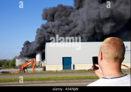 L'uomo prendendo fotografia di incendio al magazzino medico coleraine tramite telefono cellulare fotocamera Foto Stock