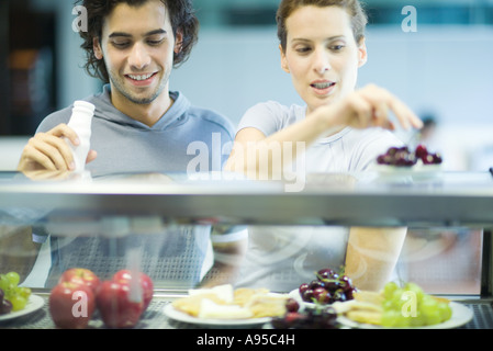 I giovani adulti in esercizio abbigliamento, scelta di snack nel club salute caff Foto Stock