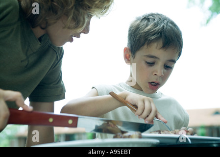 Due ragazzi guardando il pezzo di carne Foto Stock