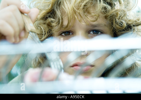 Ragazzo che guarda oltre il grill Foto Stock