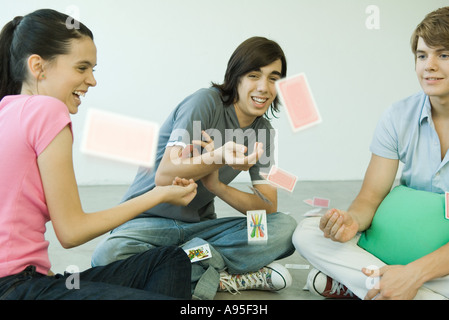 Amici di adolescenti gettando le carte da gioco in aria Foto Stock