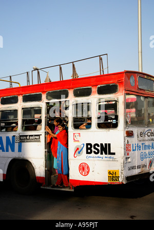 Le femmine indiane in procinto di sbarcare dal retro dell'autobus, Ahmedabad, Gujarat, India Foto Stock