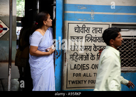 Donna indiana che si trova all'ingresso della carrozza solo per Signore, Churchgate stazione ferroviaria, Mumbai, India Foto Stock