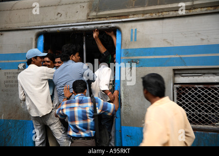 I maschi indiani si precipitavano a bordo di una carrozza affollata alla Churchgate Station di Mumbai, India Foto Stock