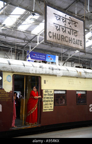 Donna indiana in piedi alla porta di solo trasporto delle Signore, Churchgate Railway Terminus, Mumbai, India Foto Stock