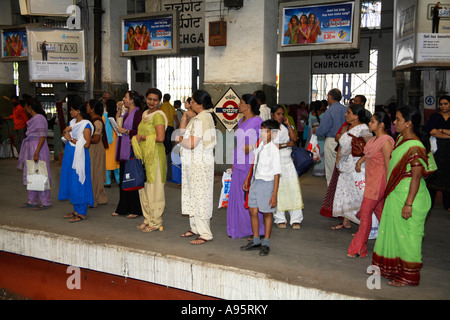 Donne indiane che aspettano sul binario alla stazione ferroviaria Churchgate, Mumbai, India Foto Stock