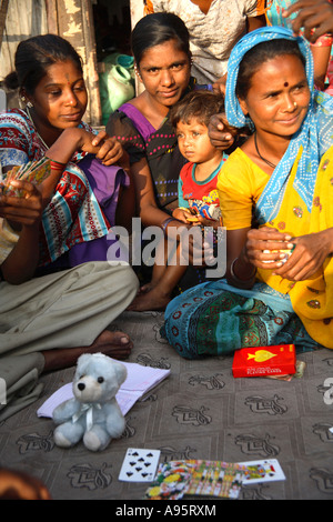 Le femmine indiane giocano le carte fuori casa di Shanty, D'Mello Road, Mumbai, India Foto Stock