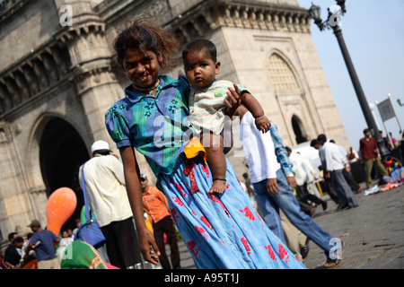 Giovane falco indiano che tiene il fratello più giovane in armi a Gateway of India, Mumbai, India Foto Stock