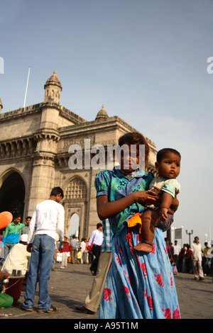 Giovane falco indiano che tiene il fratello più giovane in armi a Gateway of India, Mumbai, India Foto Stock