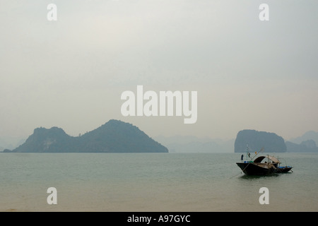 Lonely barca nella baia di Halong Foto Stock