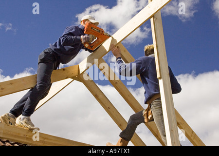 Costruttori contructing un nuovo padiglione per un'estensione di una casa utilizzando una pistola sparachiodi Foto Stock