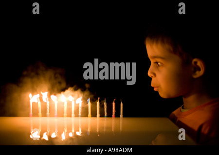 Ragazzo di età compresa tra i 5 soffia out 12 candele Foto Stock