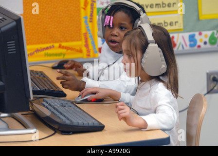 I bambini piccoli usano il computer per imparare fonica in classe Foto Stock