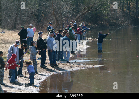 Persone si affollano le rive di un laghetto del Connecticut il primo giorno della stagione di pesca noto come giorno di apertura il tentativo di cattura della trota Foto Stock