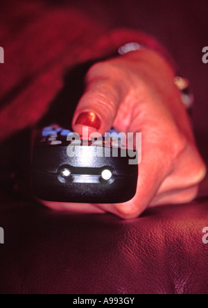 Il telecomando della tv in mano Foto Stock