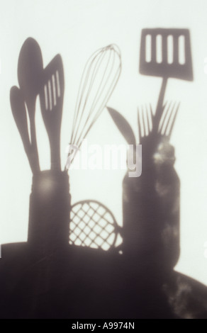 Ombra nella luce calda sul panno pallido o tenda di utensili da cucina in vasi con uno schiacciapatate compreso tra Foto Stock