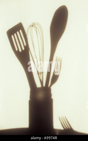 Ombra nella luce calda sul panno pallido o tenda di utensili da cucina in vaso con forcella giacente su un lato Foto Stock
