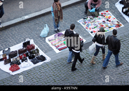 I turisti passano street trader con contraffazione di merci di designer in Roma, Italia Foto Stock