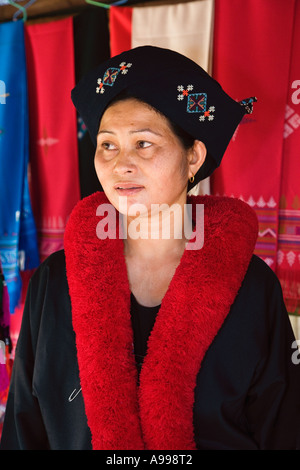 Un giovane Lu Mien donna chiamato anche Yao donna con colorate di rosso pom pom collo sciarpa nel nord della Thailandia. Foto Stock