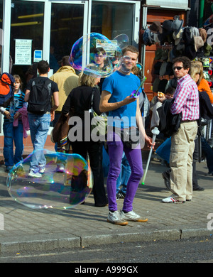 Fine settimana di lavoro - una bolla-soffiante tra gli acquirenti in 'Camden High Street', Londra Foto Stock