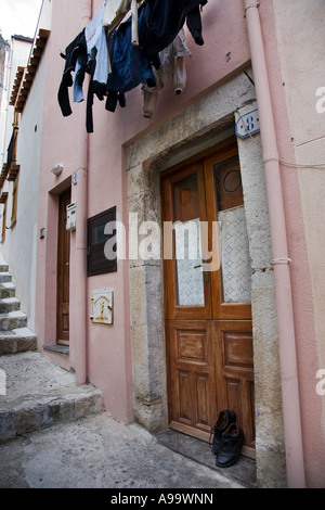 Coppia di calzature uomo sinistro esterno appartamento entrata sulla porta passo Cefalù Sicilia Italia Foto Stock