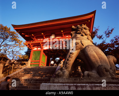 Una pietra custode lion si siede di fronte all'ingresso principale al tempio di Kiyomizu Kyoto in Giappone Foto Stock