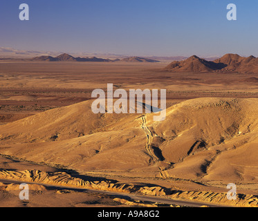 Mattina nel deserto del Sinai vicino a Eilat con roadwas e tracce in tutta vicino a dune basse colline alle spalle di Israele Foto Stock