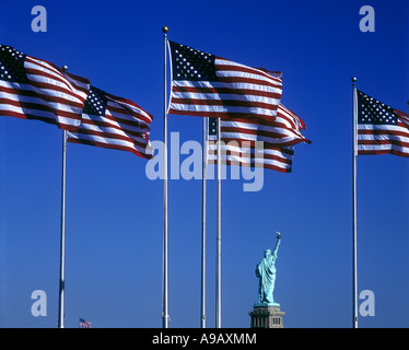 Righe di Stati Uniti bandiere Statua della Libertà monumento nazionale LIBERTY ISLAND IL PORTO DI NEW YORK NEW YORK CITY USA Foto Stock