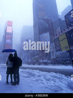 Coppia giovane IN PIEDI IN coperta di neve BLIZZARD TIMES SQUARE MANHATTAN NEW YORK CITY USA Foto Stock