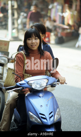 Giovane donna su uno scooter a motore in Dinh Liet St, Hanoi Old Quarter, Viet Nam Foto Stock