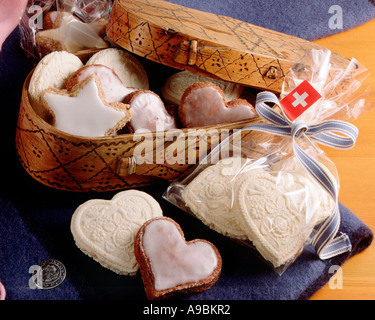 Biscotti fatti in casa a forma di cuore e stella con bandiera svizzera, scatola rustica a forma di cuore, borsa regalo e nastro. Foto Stock