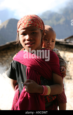 Giovane ragazza Nepalese Trasporto bambini Foto Stock