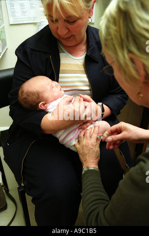 Otto settimane vecchio baby essendo dato il DTP immunizzazione da una pratica infermiera presso la clinica Foto Stock