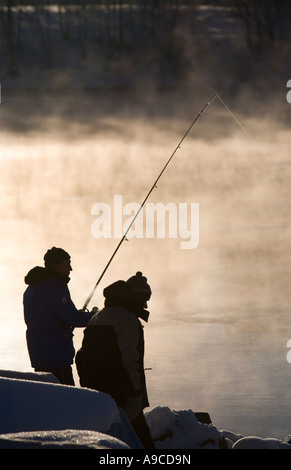 Sagome di pescatori sulla riva al freddo inverno giorno , Finlandia Foto Stock