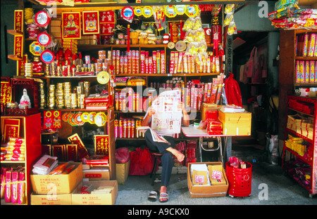 Uomo che legge il giornale al negozio di vendita carta di incenso di Hong Kong Cina Foto Stock