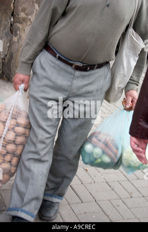 Shopper portando a casa due sacchi di verdure fresche dal polacco Balucki Rynek marciapiede mercato. Lodz Polonia Foto Stock