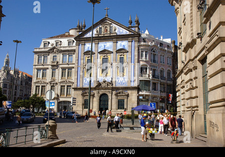 Vista magnifica chiesa imponente torre campanaria tipica architettura ecclesiastica del vecchio centro storico e trafficata strada Porto Portogallo Europa Foto Stock