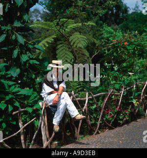 Toboggan conducente seduto su una recinzione in Monte, vicino a Funchal, Madeira, Portogallo Foto Stock