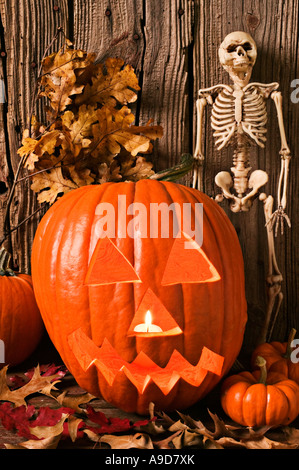 Zucca di Halloween e lo scheletro con foglie di autunno Foto Stock