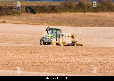 Trattore a rastrellare il terreno calcareo nel campo Foto Stock