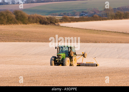 Trattore a rastrellare il terreno calcareo nel campo Foto Stock