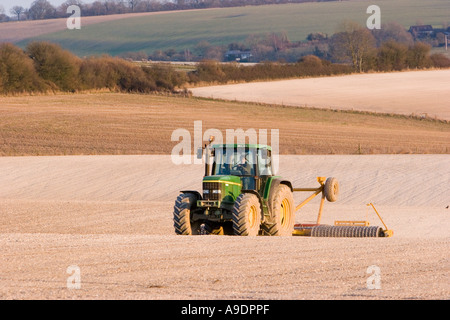 Trattore a rastrellare il terreno calcareo nel campo Foto Stock