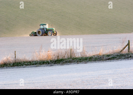 Trattore a rastrellare il terreno calcareo nel campo Foto Stock