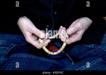 Le mani di una donna practitioner buddista tenendo una mala durante la meditazione Foto Stock