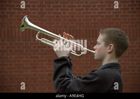 "Giovane musicista maschio a suonare la tromba in ottone' Foto Stock