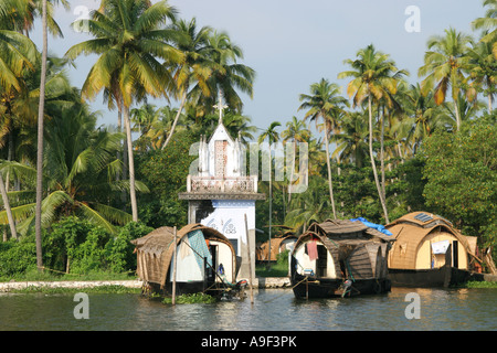 Case galleggianti ormeggiate accanto a una piccola chiesa sulle rive del Backwaters vicino a Alappuzha (Alleppey), Kerala, India del Sud Foto Stock