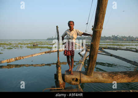 Fisherman lavorando sui cinesi reti da pesca in posa per una fotografia di Kochi (Cochin), Kerala, India del Sud Foto Stock