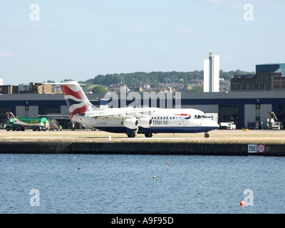 London City Airport British Airways 4 quattro passeggeri motore jet tassazione sulla pista con il vecchio acque dock East London Docklands Newham Regno Unito Inghilterra Foto Stock