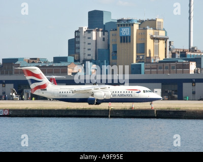 London City Airport British Airways quattro passeggeri motore jet tassazione sulla pista Tate and Lyle Silvertown raffineria di zucchero oltre a Londra REGNO UNITO Foto Stock