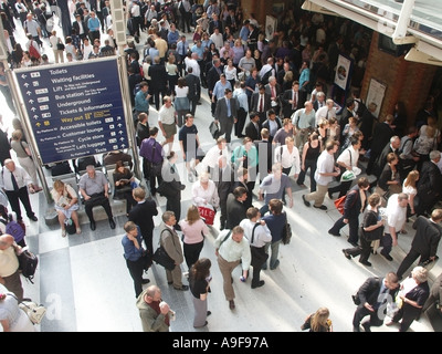 Stazione ferroviaria in attesa & ritardi per la folla di persone alla stazione ferroviaria di Liverpool Street City di Londra come pendolari attendere per il trasporto home UK Foto Stock